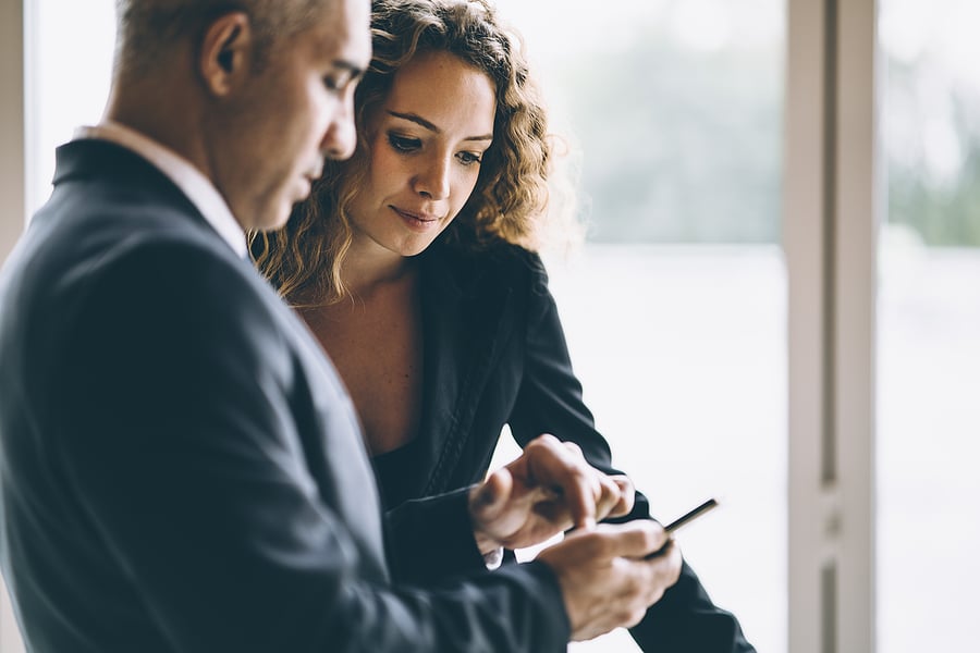 Scene Of Business Woman Looking At The Cellphone Of Her Colleagu